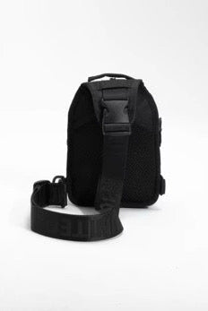 The Born United Private Label Black Phantom Tactical Sling-Pac - 4L is shown upright on a white background, featuring a compact rectangular shape and a wide adjustable strap extended in front for easy carrying.