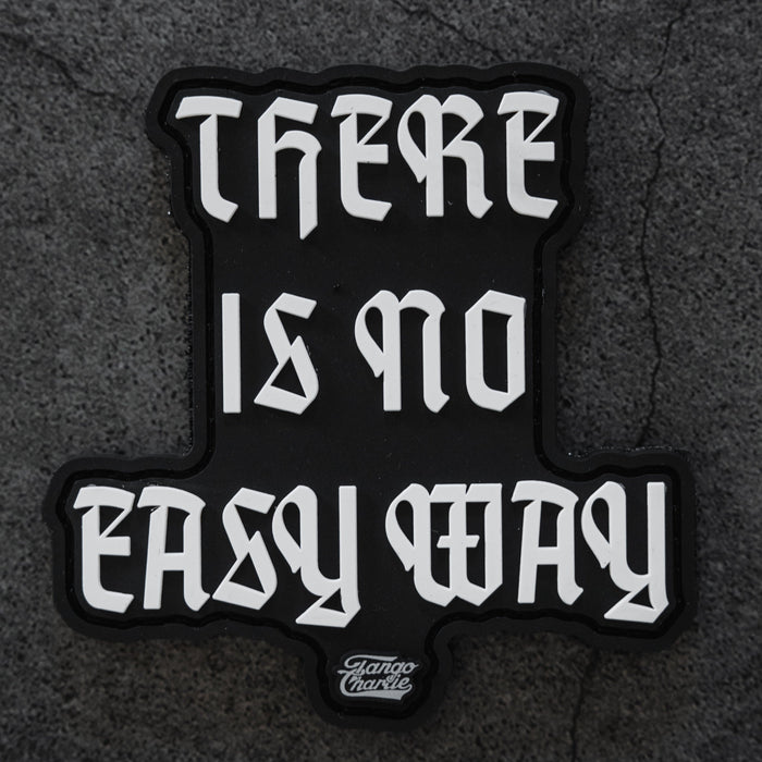 The There’s No Easy Way - Patch by Tango Charlie Apparel is a black 3-inch patch with bold white gothic lettering reading “THERE IS NO EASY WAY” on a textured gray background.