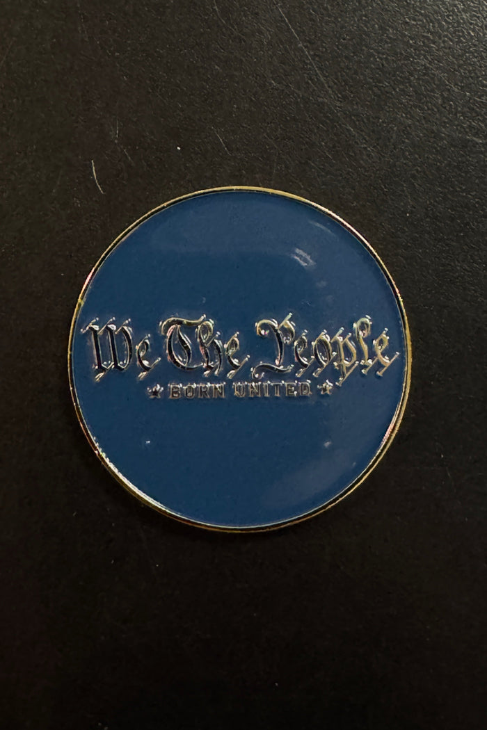 Certainly! Hereโs a rewritten sentence using the provided product data: The Born United Private Label โWe The People Challenge Coinโ features a round blue design with gold trim and showcases the words โWe The Peopleโ and โBorn Unitedโ in silver gothic-style lettering, evoking the look of a classic challenge coin.