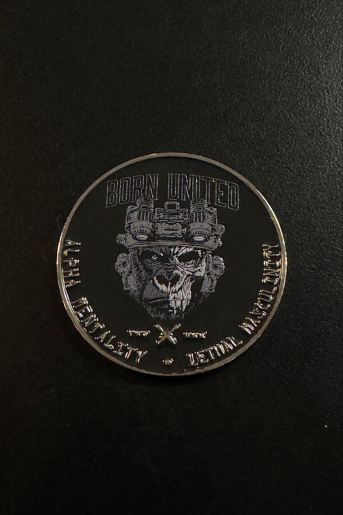 A round silver challenge coin featuring a military skull emblem and the text 'BORN UNITED' and 'DEADLY VALUABLE - BORN TO WIN' on a dark background.