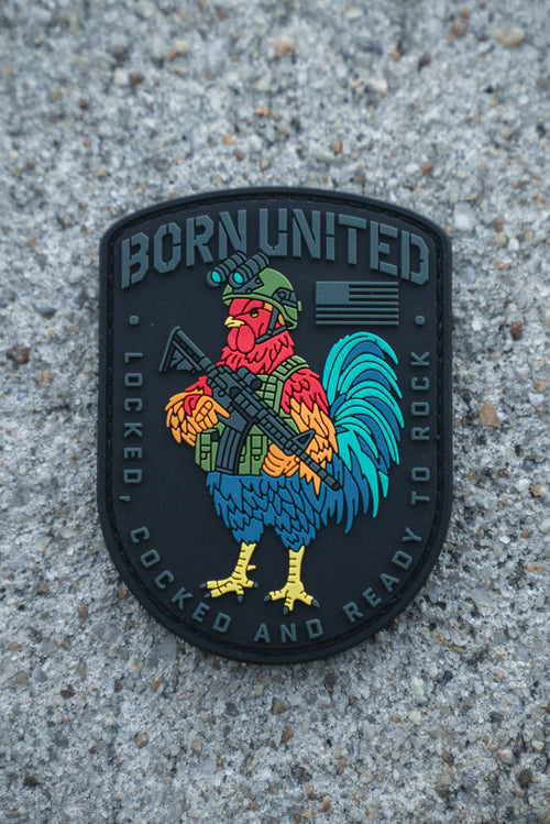 The Battle Bird PVC Patch by Born United Private Label features a colorful rooster in military gear with a rifle, “BORN UNITED” at the top, and “LOCKED, COCKED AND READY TO ROCK” at the bottom, set against a rough concrete surface.