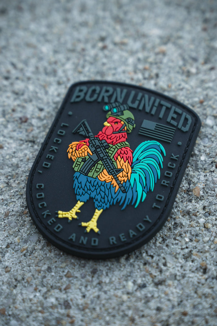 The Battle Bird PVC Patch by Born United Private Label features a rooster in military gear with a rifle, displaying "BORN UNITED" at the top and "LOCKED, COCKED AND READY TO ROCK" around the bottom edge.