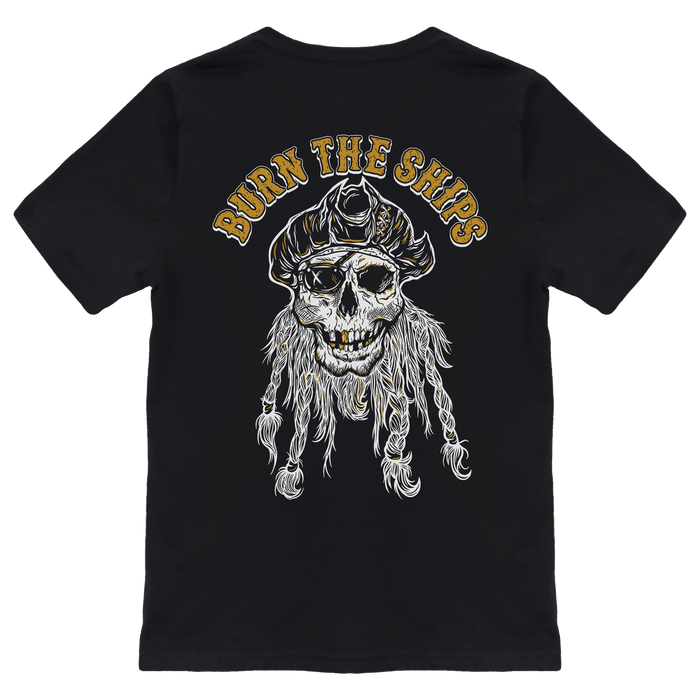 The Relentless Betrayal Burn The Ships Gold & White Tee is a unisex cotton T-shirt featuring a pirate skull in a tricorn hat, with BURN THE SHIPS in bold gold lettering.