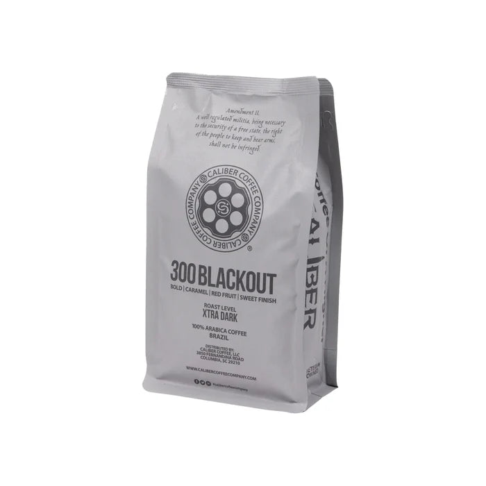 A 300 Blackout bag from Caliber Coffee Company offers a specialty-grade, single-origin dark roast with bold caramel and red fruit notes and a sweet finish. Packaged in gray with black text, its made from 100% Arabica beans from Brazil.