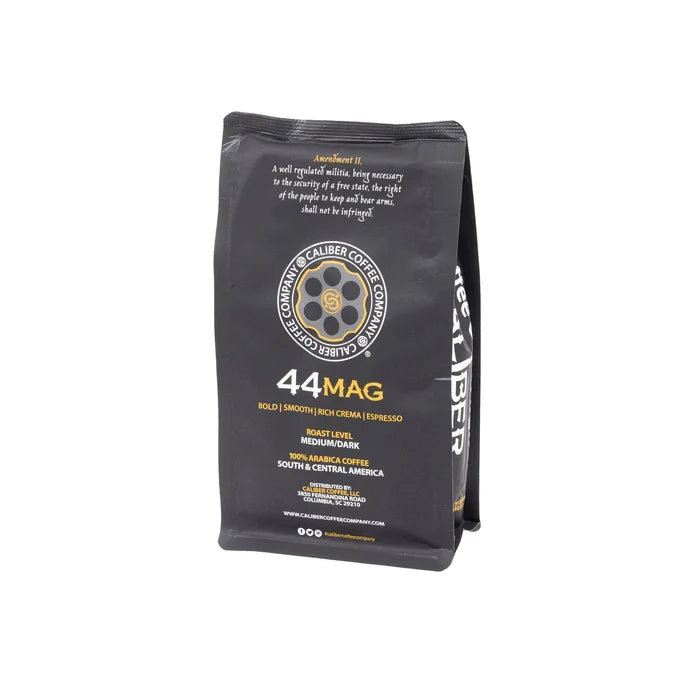 A black bag of Caliber Coffee Companys Caliber Espresso Roast .44 Mag whole bean coffee spotlights its artisan-roasted, specialty-grade blend. The packaging details the roast level, flavor profile, and origin—a crafted blend from Central and South America using 100% Arabica beans.