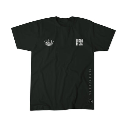 The 13th Christ is King Premium Tee is a black shirt with a white crown graphic on the left chest, "CHRIST IS KING" text on the right, vertical "Christ" along the right side, and "13TH" with a cross near the bottom hem.