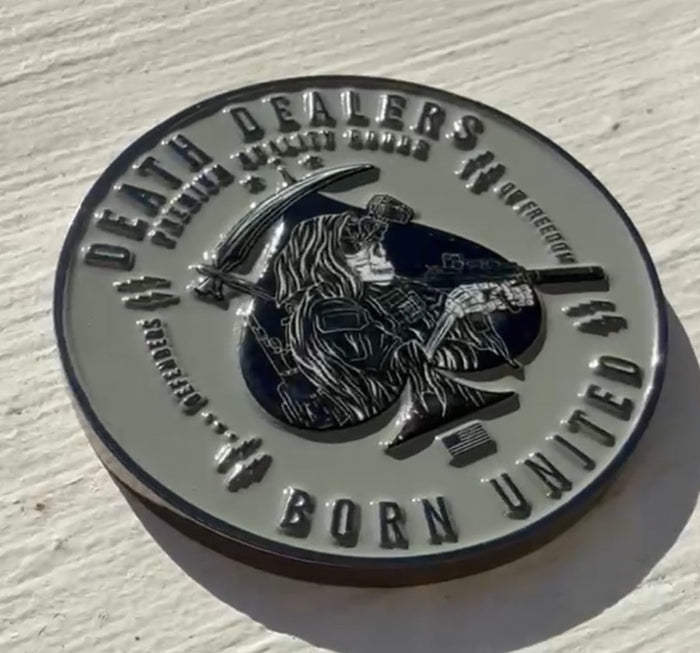 The Death Dealer Challenge coin by Born United Private Label is a military-style, round piece featuring a warrior with a rifle and scythe bearing Death Dealers and the elegantly inscribed phrase Born United, enhancing its striking design.