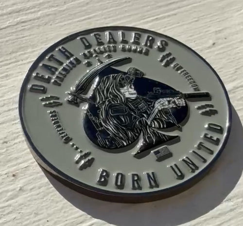 The Death Dealer Challenge coin by Born United Private Label is a military-style, round piece featuring a warrior with a rifle and scythe bearing Death Dealers and the elegantly inscribed phrase Born United, enhancing its striking design.