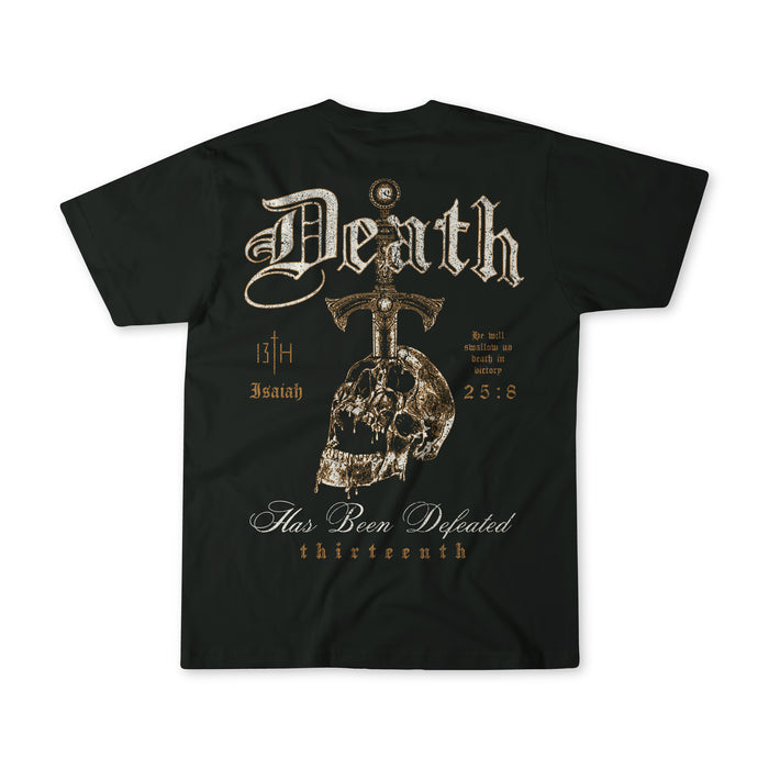 The Death's Defeat Premium Tee by 13th features a gothic design with "Death," a large cross, skull details, and Isaiah 25:8. Stylized text includes "Has Been Defeated" and "thirteenth," sharing a message of spiritual hope.