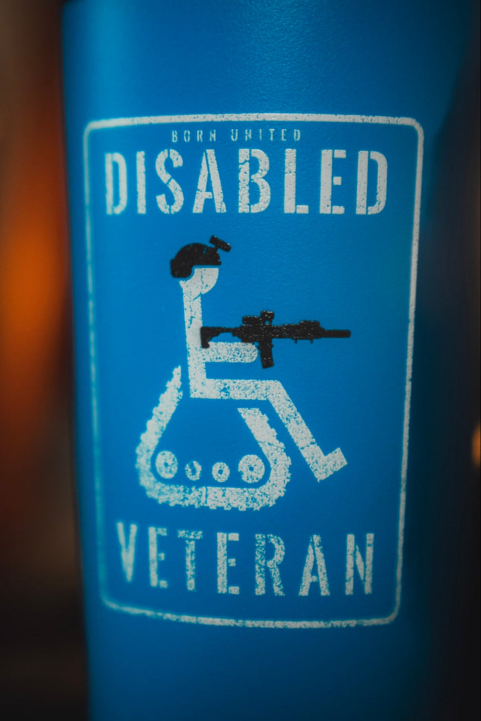 The Disabled Vet Tumbler - 20oz by Born United Private Label features a blue design with a wheelchair symbol and rifle, labeled "Disabled Veteran" in white distressed text—perfect as a veteran gift or for daily use.