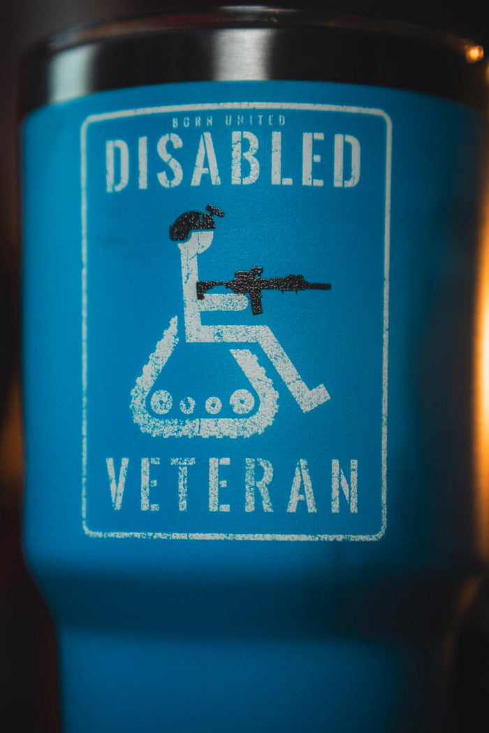 A close-up of the Born United Private Label Disabled Vet Tumbler - 30oz, showing a person in a wheelchair with a rifle and “Disabled Veteran” text above and below the graphic.