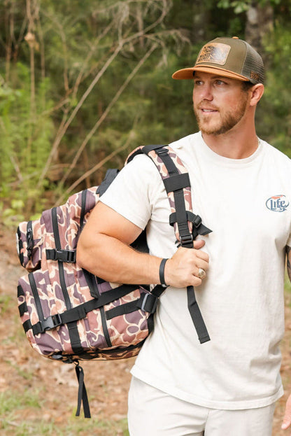 Man with a camouflage backpack in a forest setting