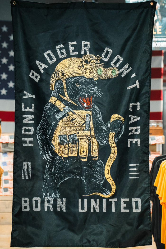 The Born United Private Label Honey Badgerin' Flag features a black banner with a bear in a helmet and yellow vest, crafted from durable polyester for lasting style.