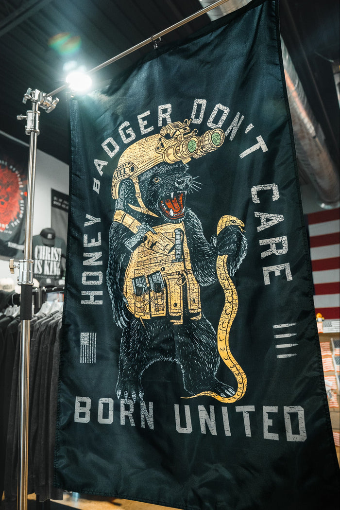 The Honey Badgerin’ Flag by Born United Private Label is a large black durable polyester flag showing a tactical honey badger with night-vision goggles and a snake, plus “HONEY BADGER DONT CARE BORN UNITED”—perfect for fearless displays in any space.