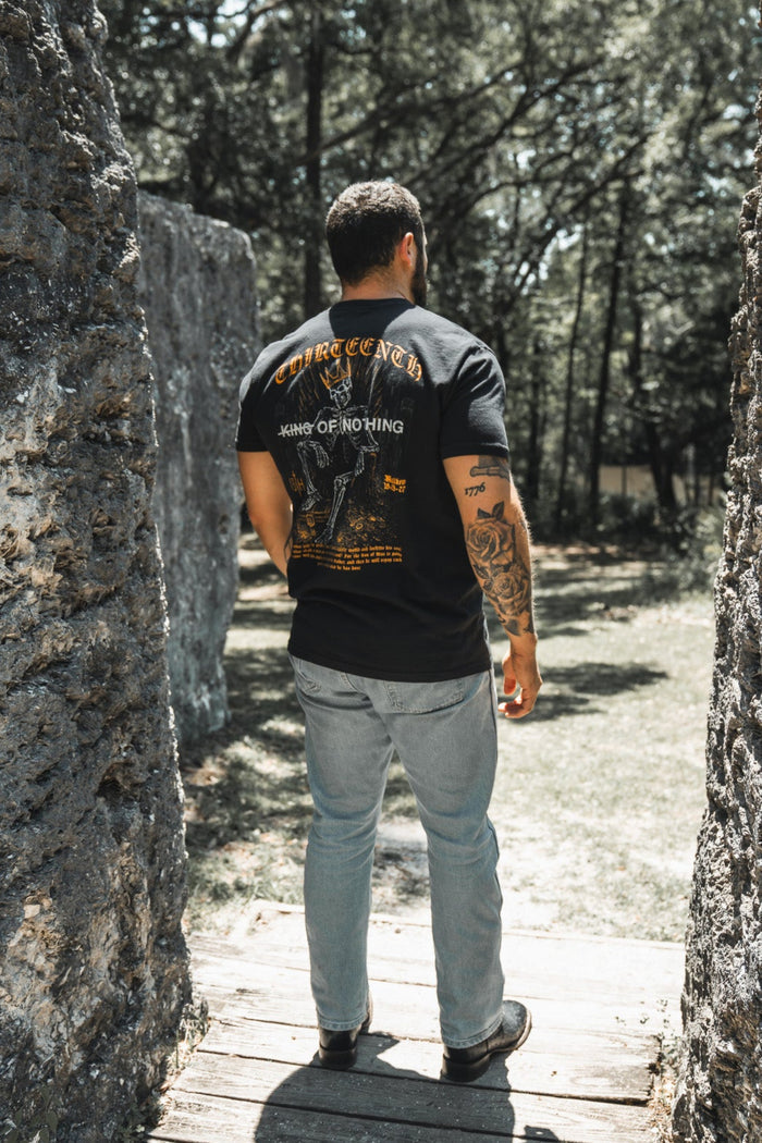 Man walking through a stone archway in a forest