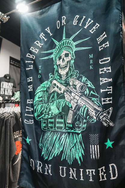 The Liberty or Death Flag by Born United Private Label features a skeletal Lady Liberty with a rifle and the words “Give Me Liberty Or Give Me Death” and “Born United”—a bold piece inspired by revolutionary spirit.