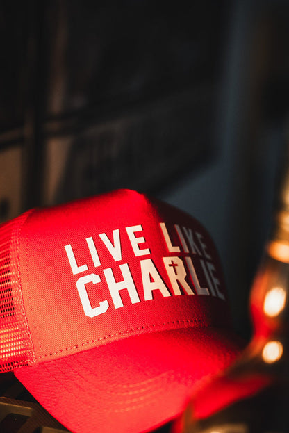 The Born United Private Label "Live Like Charlie Trucker Snapback" is a red mesh baseball cap with a curved brim, featuring the bold white phrase LIVE LIKE CHARLIE on the front.