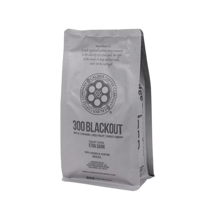 A gray coffee bag from Caliber Coffee Company, labeled Caliber Dark Roast 300 Blackout - Ground, features bold caramel and red fruit notes with a sweet finish. This XTRA dark roast is specialty grade coffee made from 100% single-origin Arabica beans sourced from Brazil, South America.