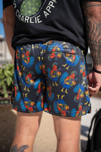 A person outdoors displays only their lower back, legs, and the vibrant Men's Mesh Lifestyle Shorts | 5.5" - Battle Bird by Born United Private Label, highlighting the lively rooster-print design and comfortable fit.