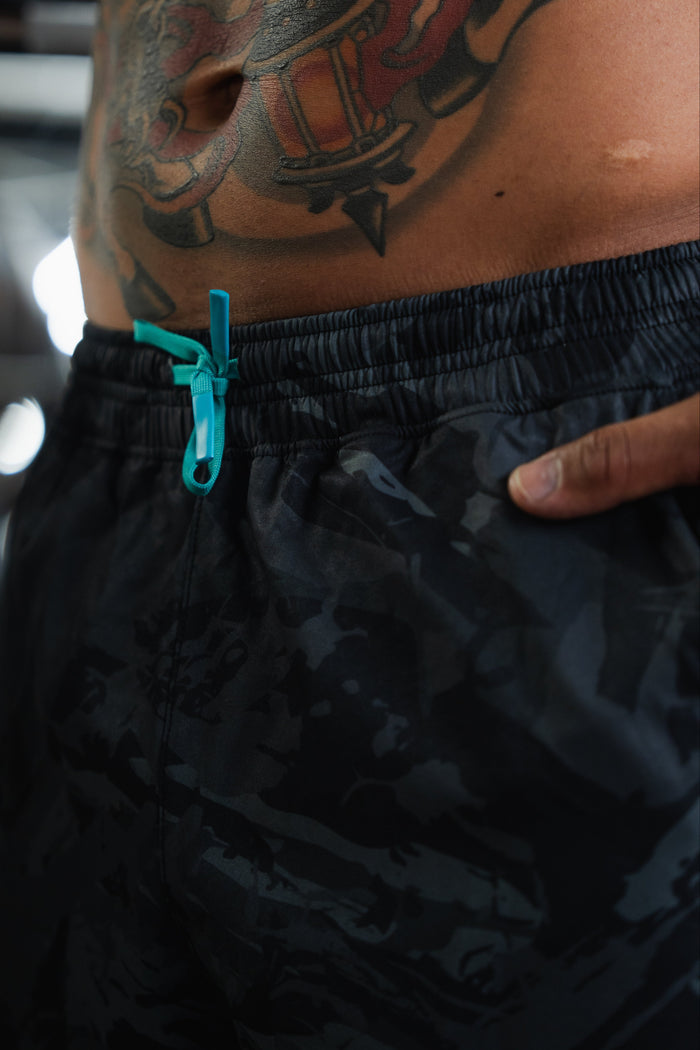 Black camouflage shorts with 'Give Me Liberty' text on a blurred background