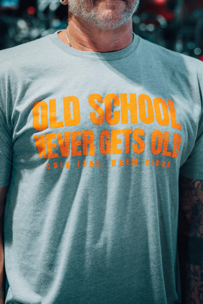 Man wearing a gray t-shirt with 'Old School Never Gets Old' text in orange.