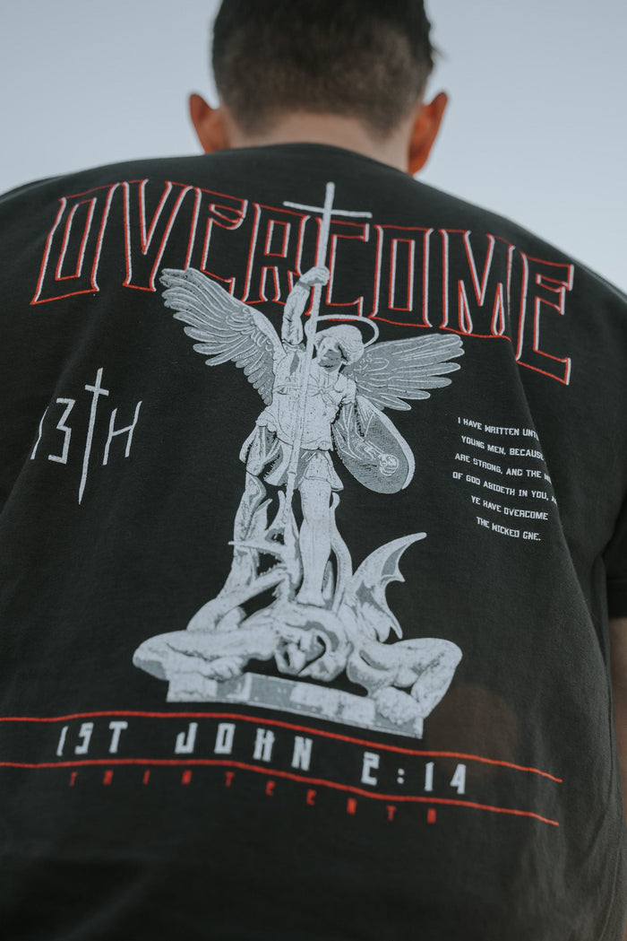 Young men will like the Overcome Premium Tee by 13th, a black T-shirt with red OVERCOME and 13TH, featuring an angel with a sword over a fallen figure. The message from 1st John 2:14 is powerful and grounded in scripture.