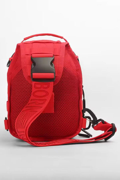 The Born United Private Label Red Reaper Tactical Sling-Pac - 4L features a bold red design, wide adjustable strap, mesh back panel, and large black buckle; shown upright against a white background for a stylish, functional look.