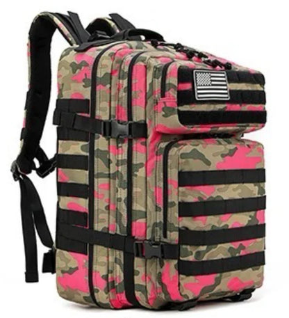 The Born United Private Label Standard Tac-Pac Ultimate Bundle is a camouflage backpack with pink accents, black straps, multiple compartments, and assorted front patches—including an American flag patch.