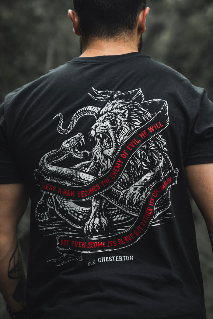 A man wears The Last Stand by Born United Private Label: a black limited edition tee with a white lion vs. serpent graphic and red text, "Unless a man becomes the enemy of evil, he will not even become its slave but rather its champion.