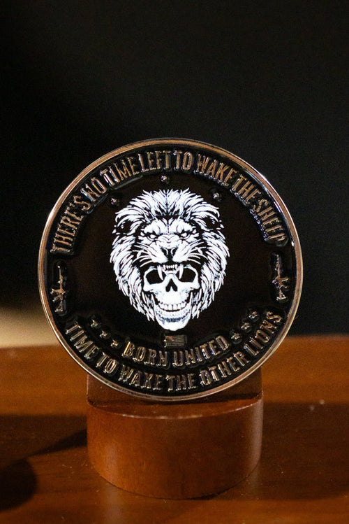The Born United Private Label Waking Lions Challenge Coin displays a roaring lion and the quote "THERE'S NO TIME LEFT TO WAKE THE SHEEP, IT'S TIME TO WAKE THE OTHER LIONS," shown upright on a wooden surface.
