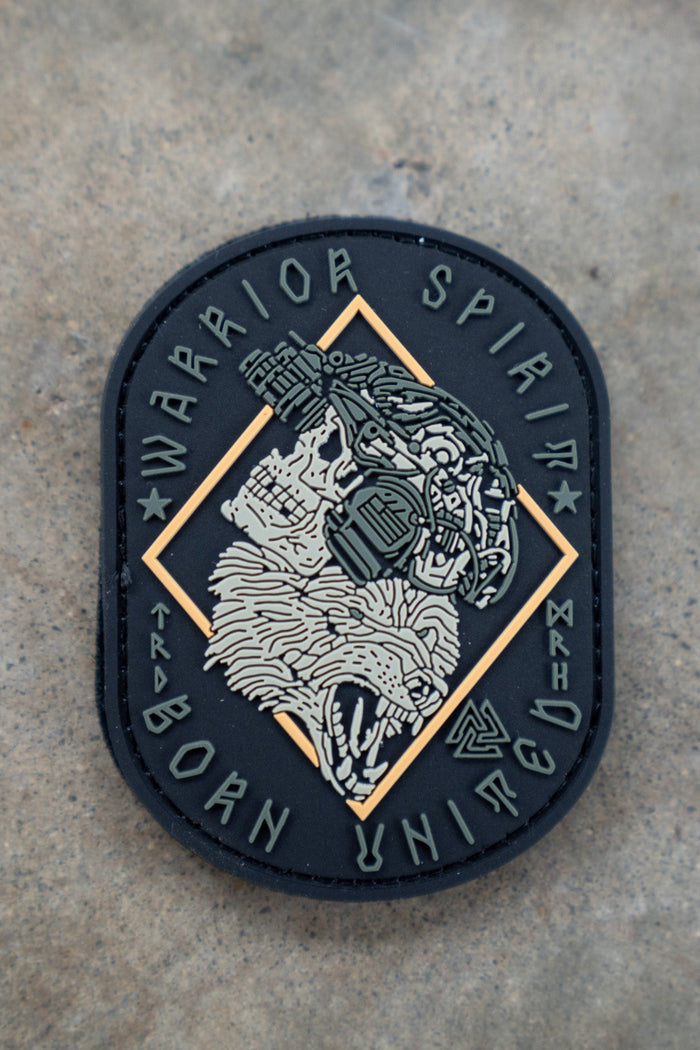 The Warrior Spirit PVC Patch by Born United Private Label features a roaring bear’s head with cyborg details, framed by “WARRIOR SPIRIT” on top and “BORN UNITED” below, set against a textured background.